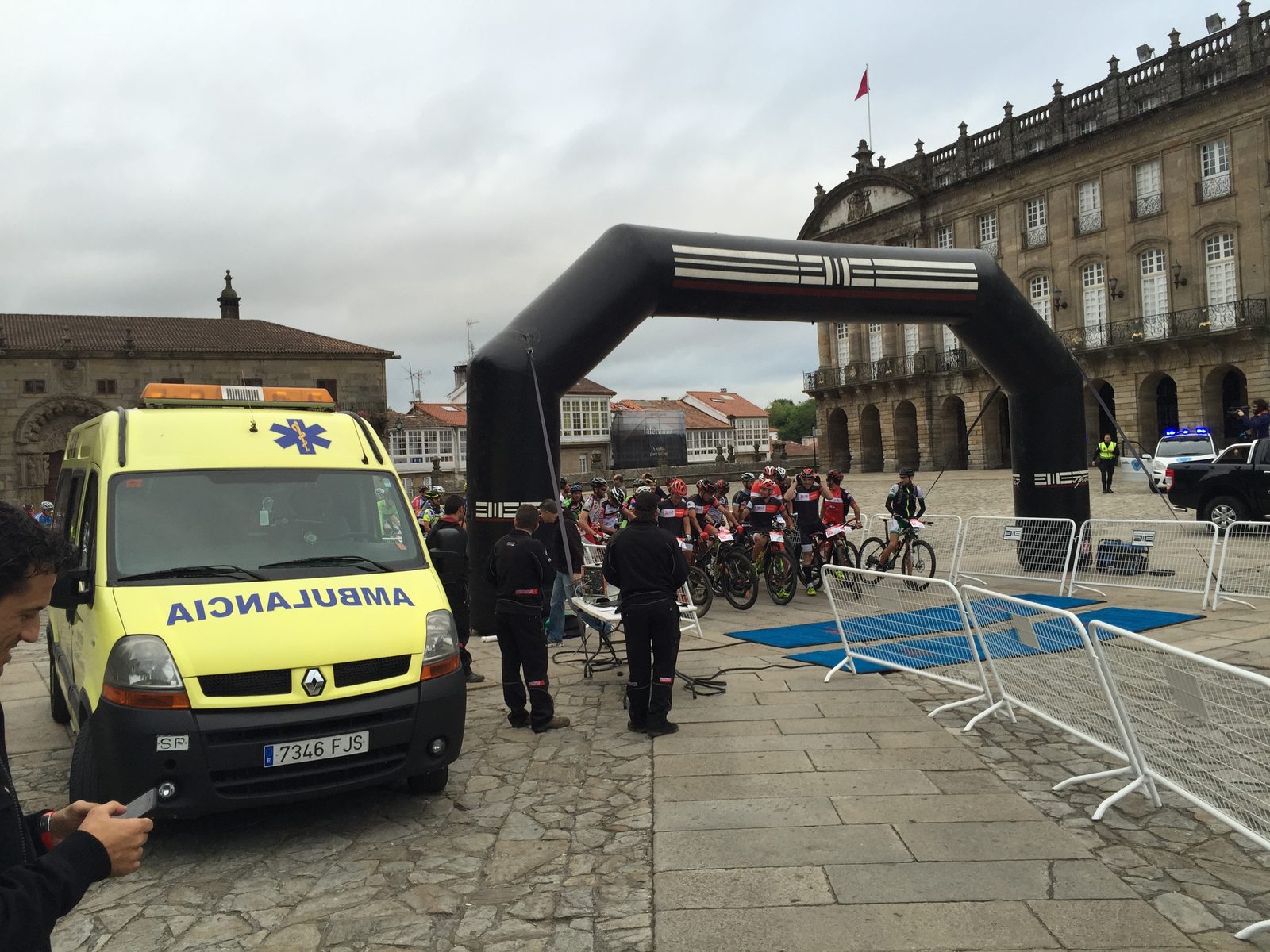 Ambulancia de Ambulancias do Nordés junto al arco de salida de una carrera de bicicleta de montaña en el casco histórico de Santiago