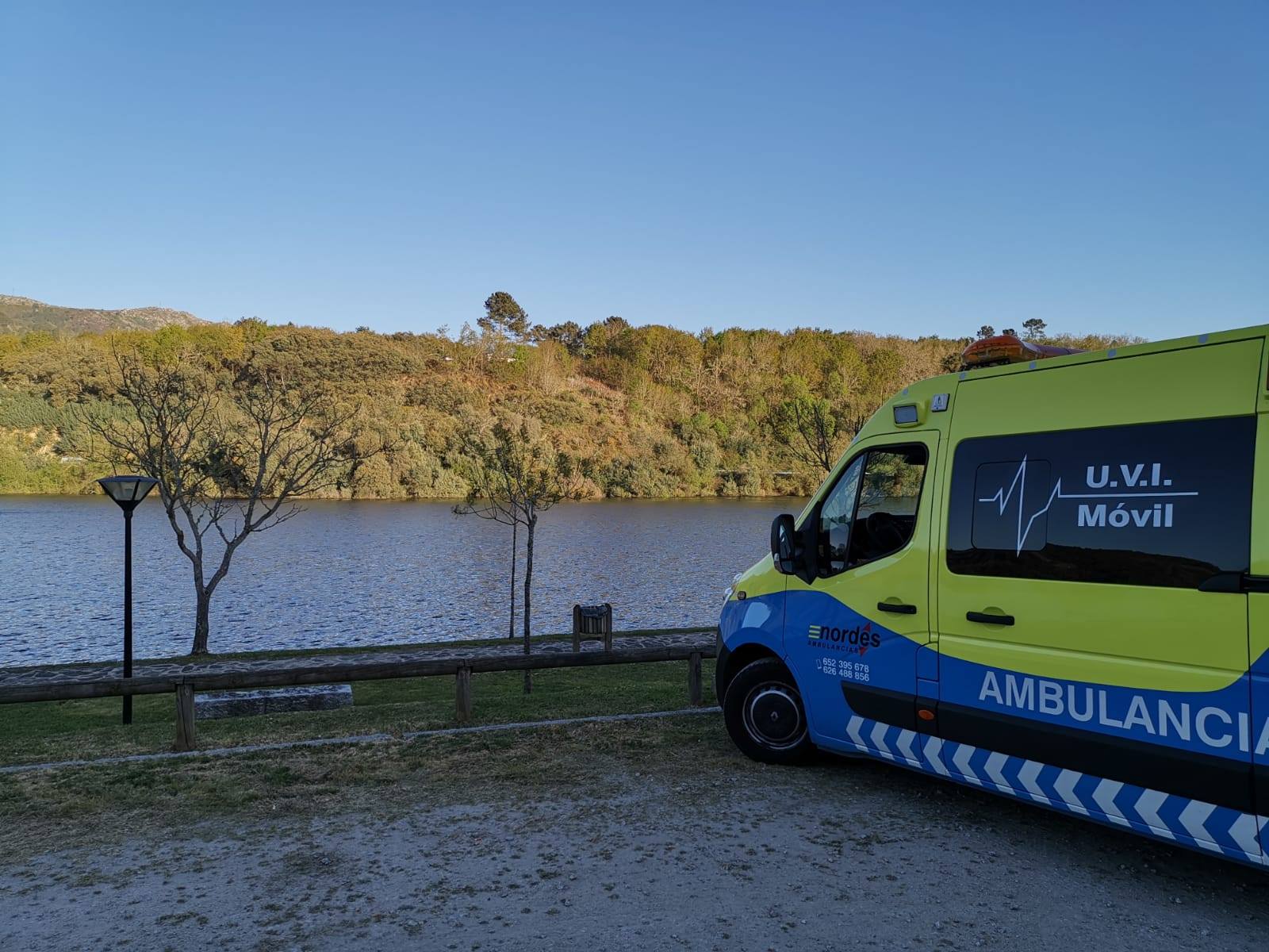 Ambulancia medicalizada U.V.I. Móvil de Ambulancias do Nordés estacionada junto a un embalse al atardecer